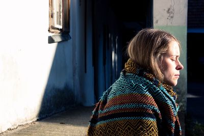 Profile view of young woman with eyes closed sitting outdoors