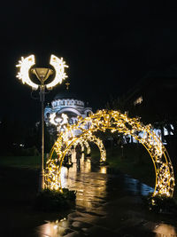 Illuminated bridge in city against sky at night