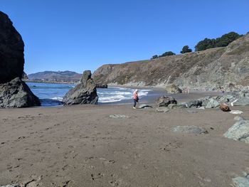 People on beach against clear sky