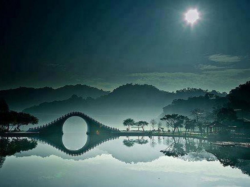 water, reflection, tranquility, tranquil scene, mountain, scenics, beauty in nature, sky, nature, lake, waterfront, mountain range, river, sun, idyllic, connection, bridge - man made structure, tree, sunlight, calm