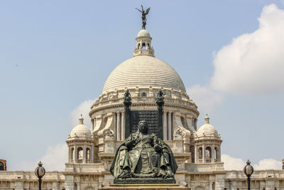 Low angle view of statue and building against sky