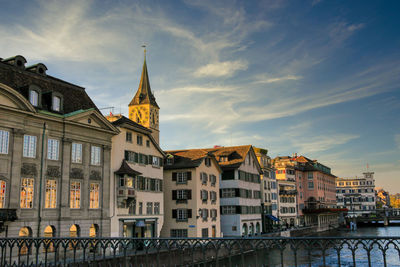 Buildings in city against cloudy sky