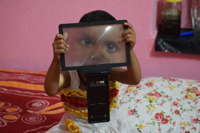 Portrait of girl holding magnifying glass