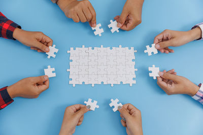 Cropped hands of person playing jigsaw puzzle