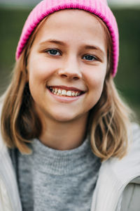 Portrait of smiling stylish teenage girl wearing pink fashion cap