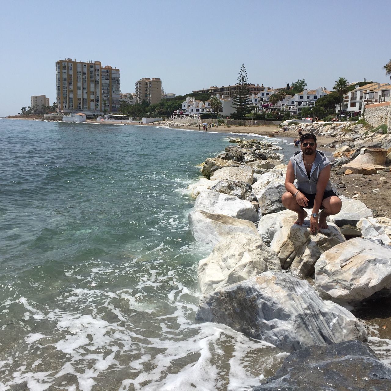 water, building exterior, architecture, built structure, sea, rock - object, city, clear sky, leisure activity, lifestyles, waterfront, men, city life, person, tourist, travel, rock formation, travel destinations