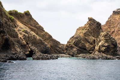 Rock formations by sea against sky