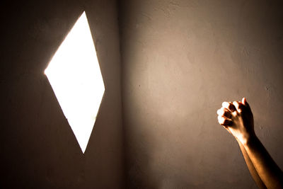 Close-up of praying hand holding illuminated light