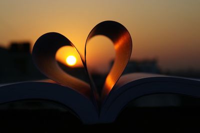 Close-up of heart shape against sky during sunset