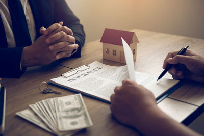 Cropped image of people with text on paper at table