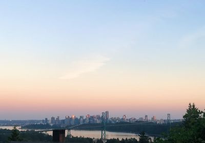 Buildings in city against sky during sunset