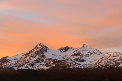 Scenic view of snowcapped mountains against sky during sunset