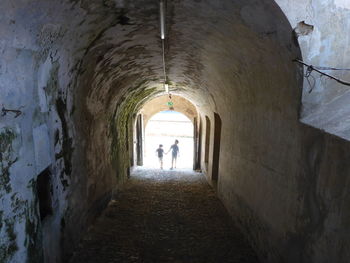 Rear view of people walking in alley amidst buildings