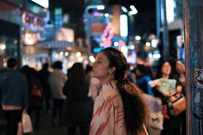 Women standing in city at night