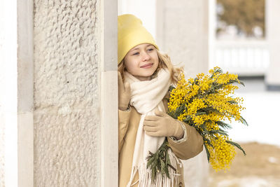 A girl  with a bouquet of mimosa in her hands. spring, international women's day march 8