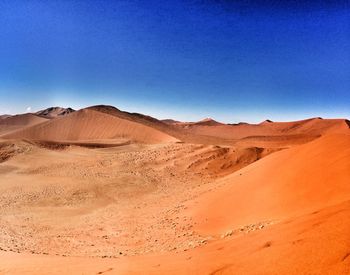 Scenic view of desert against blue sky