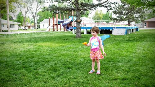 Girl standing on grassy field in park