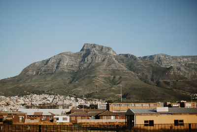 Town by mountain against clear sky