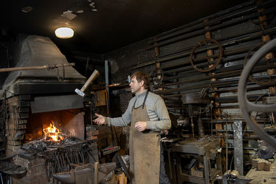A blacksmith throws a hammer in his workshop