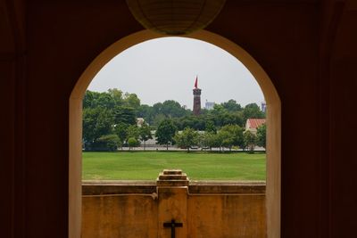 Rear view of woman standing by historic building