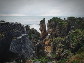 Panoramic view of rocks on beach against sky