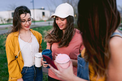 Happy young woman drinking water from outdoors