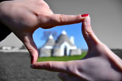 Cropped image of man holding hands against building