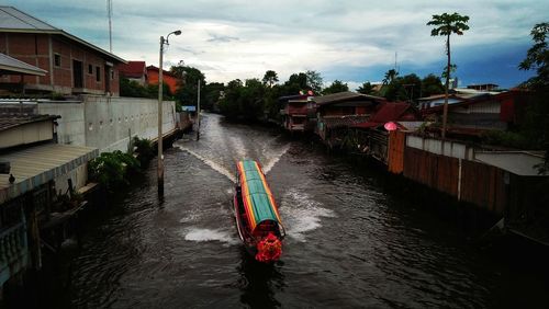 River amidst houses and buildings against sky