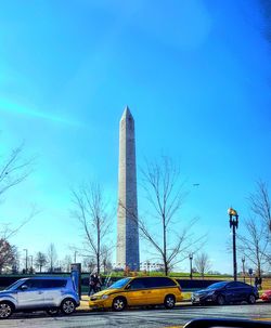 Cars in city against clear blue sky