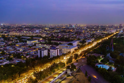 High angle view of illuminated cityscape against sky at night