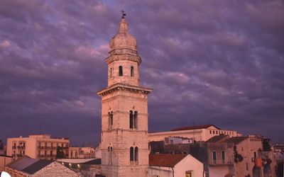 View of buildings in city against cloudy sky