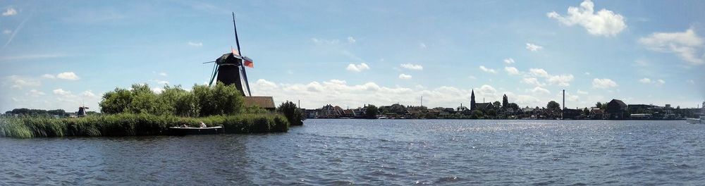 Traditional windmill by river at zaanse schans