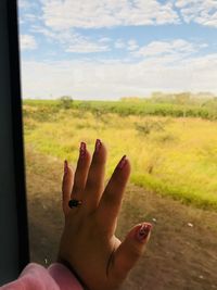 Midsection of woman with hand on window