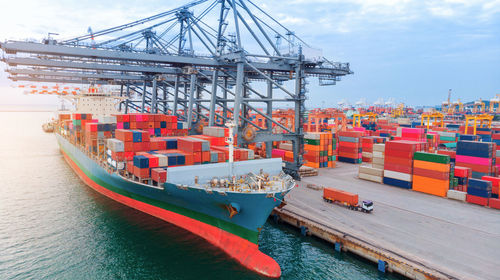 Aerial of cargo container ship carrying container under big crane loading cargo import and export 