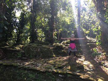 Woman by trees in forest