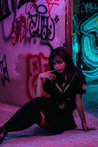 Full length of woman sitting on wall