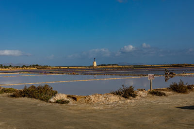 Scenic view of beach against blue sky