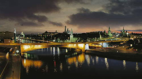 Illuminated bridge over river at night