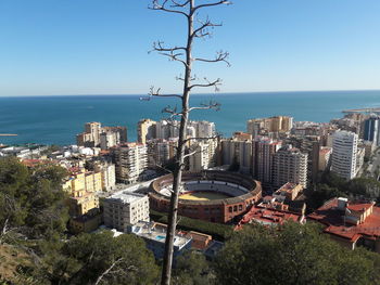 High angle view of buildings and sea against clear sky