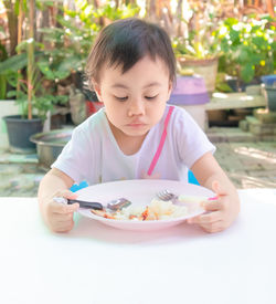 Cute girl holding food in bowl