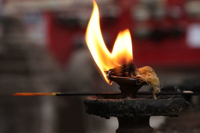 Close-up of lit diya at temple