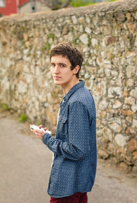Portrait of young man using mobile phone outdoors
