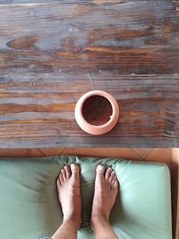 Low section of person standing on pillow by empty pot