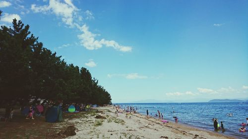 People on beach against sky