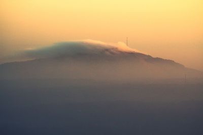 Scenic view of fog against sky during sunset