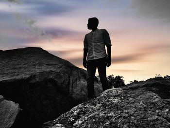 Rear view of man standing on rock