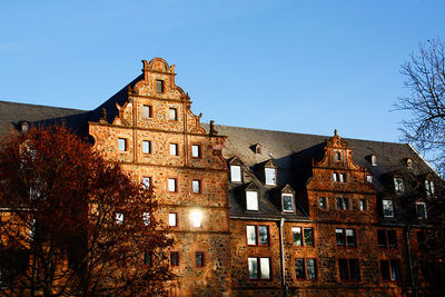 Low angle view of old building against clear blue sky