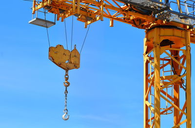 Low angle view of crane against sky