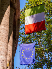 Low angle view of flags against built structure