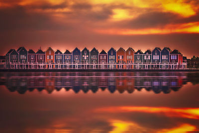 Reflection of building in sea during sunset